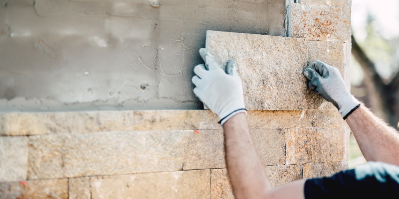 Man installing brick to wall