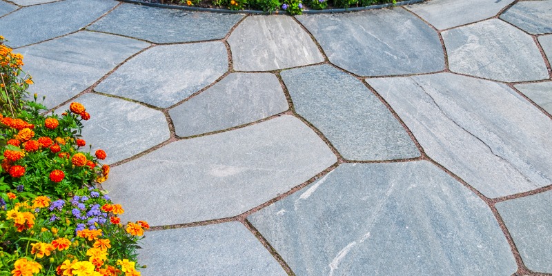 flagstone patio surrounded by flowers