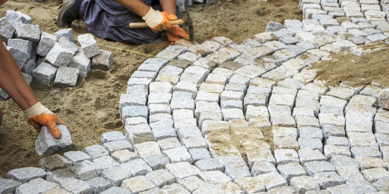 Men placing stones for patio