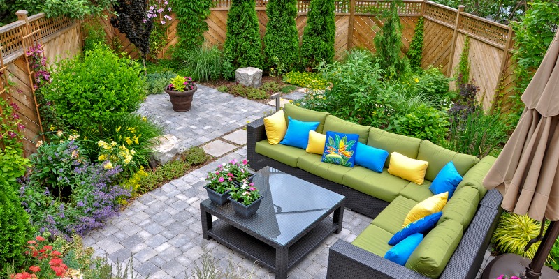 Landscaped backyard patio with furniture - Patio Paver FAQ: Everything You Need to Know